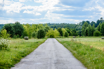 Fototapeta na wymiar romantic gravel road in country under blue sky