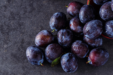 top view ripe plums over dark table background .