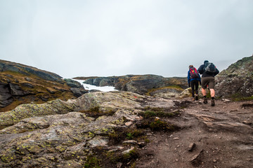 Fototapeta premium Tired happy people during beautiful Norway trip early morning in summer. Trolltunga hiking route. Norway