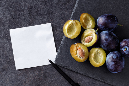 plums, whole and slices with blank card add own text.
