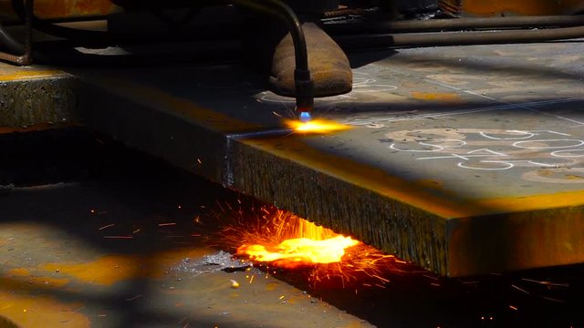 Worker Cutting Metal with a gas Flame torch in Metal industry