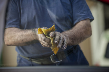 The man is wiping his dirty hands. Body shop