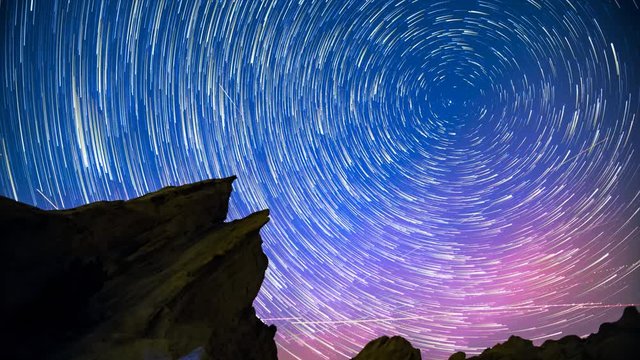 Star Trails in Night Sky Over Rock/Desert