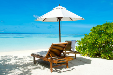 Beautiful landscape with sunbeds and umbrellas on the sandy beach, Maldives island