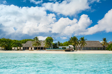 Fototapeta na wymiar Beautiful sandy beach with sunbeds and pool in Indian ocean, Maldives island