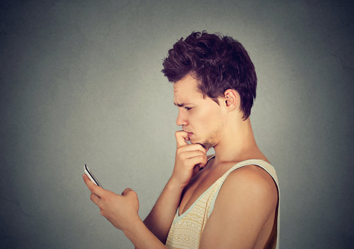 man looking confused at his mobile phone