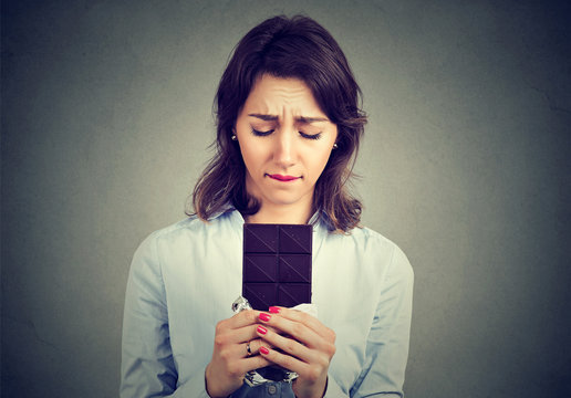 Woman tired of diet restrictions craving chocolate bar