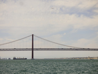 Fototapeta na wymiar The bridge 25th of April viewed from the other side of river Tagus - Cacilhas, Almada