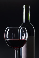 Bottle and glass of red wine .