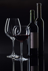 Bottles and glass of red wine .
