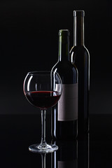 Bottles and glass of red wine .