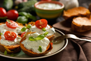 Baked sweet potatoes served with tzatziki dip.