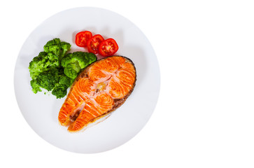 Salmon steak fillet with broccoli on plate. top view. isolated on white