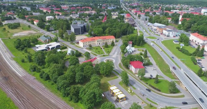 Aerial Footage. Drone flying around the city at sunny day. City streets, roads, roundabouts, bridges and buildings.