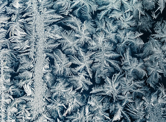 beautiful ornate festive frosty pattern on glass winter window
