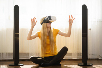 Girl wearing virtual reality goggles at home