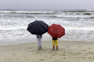 dzieci na plaży w czasie deszczu - obrazy, fototapety, plakaty
