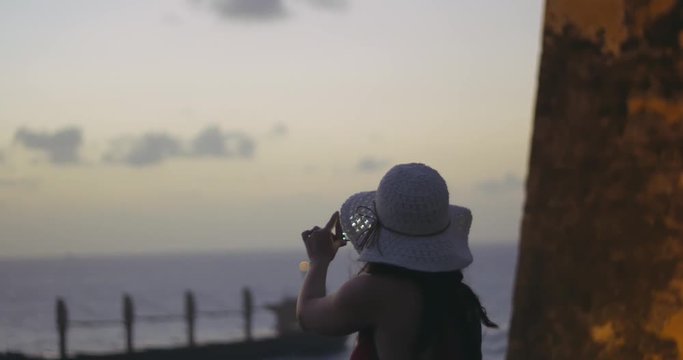 Slow motion of woman taking pictures on mobile of beautiful view during sunset