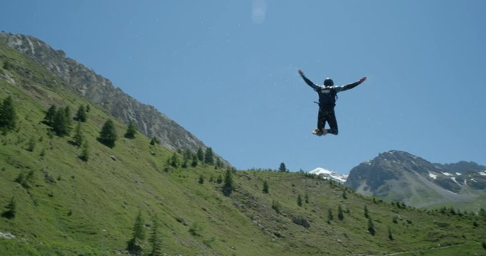 A man flying through the air from a water jump lands in a lake with a splash