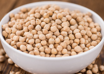 Portion of dried Chickpeas on wooden background, selective focus