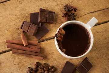 Closeup shot of freshly cup of coffee with cinnamon, coffee beans, cinnamon sticks anise and...