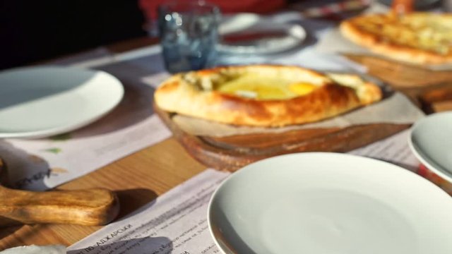 Khachapuri, traditional dish of Georgian cuisine, open cheese pie with egg yolk