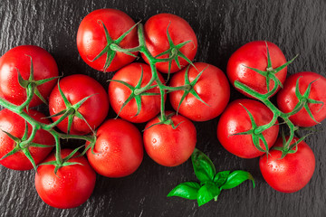A pile of fresh , ripe , delicious red tomatoes on a black stone. Summer market agriculture farm full of organic vegetables. Can be used as background.