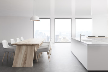 White kitchen with three windows and a table