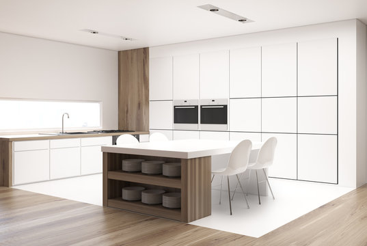 White kitchen with a table and countertops side