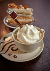 Cup of vienna coffee with cream and cinnamon on the wooden table in cafe