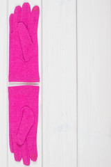 Pink gloves for woman on white boards, clothing for autumn or winter, copy space for text
