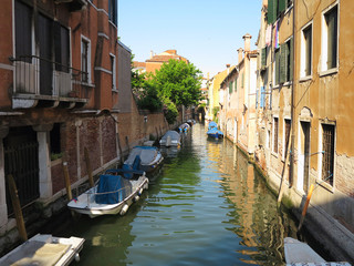 Fototapeta na wymiar 20.06.2017, Venice, Italy: Canal with boats and colorful facades of medieval houses
