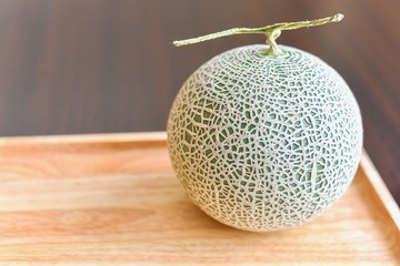 Close-Up View of Green Cantaloupe Melon Isolated on Wooden Board