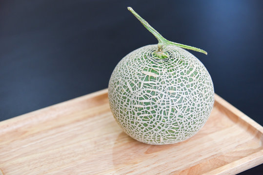 Green Cantaloupe Melon Isolated on Wooden Board