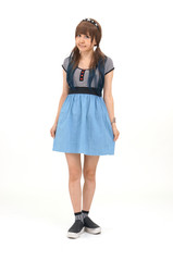 カジュアルな服装の女性が、白い背景の前でポーズしています