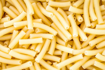 Close up full frame of dry uncooked macaroni. Food Background.