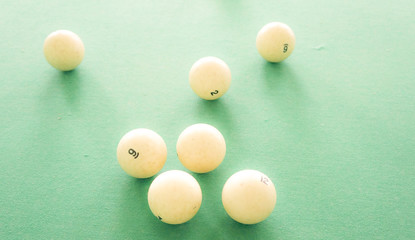 Big white billiard balls on green cloth