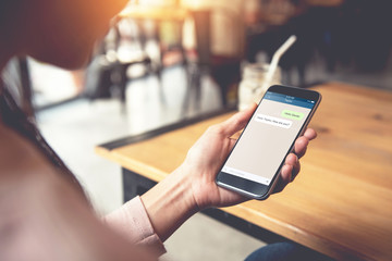 Closeup woman hand holding smart phone, Mock up to screen chat box. Social network, Chating and messaging concept.
