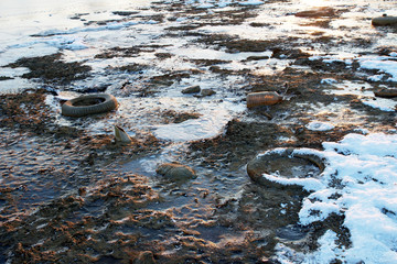Garbage in frozen mud and snow