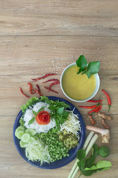 Thai rice noodle eaten with curry and veg. thai food (Thai language Kanom jeen) on blue dish and green bowl,