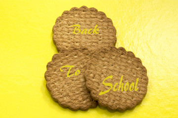 Wholemeal cookies with concept of back to school on yellow background