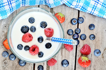 White yogurt in a bowl with blueberries, raspberries and strawberries