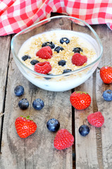White yogurt in a bowl with oatmeal, blueberries, raspberries and strawberries