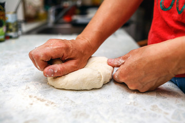 Female hands knead homemade pizza dough