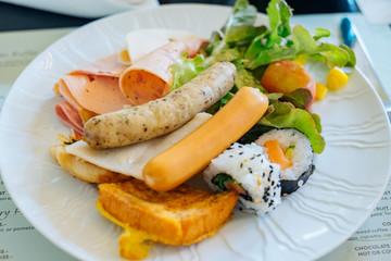 American breakfast with sausage ham sliced bread and sushi