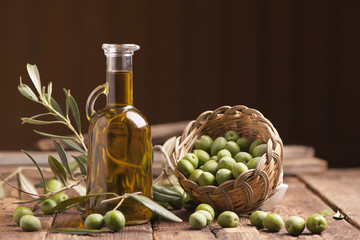 Olive oil and olives on wooden rustic table