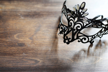 Black mask on the wooden background
