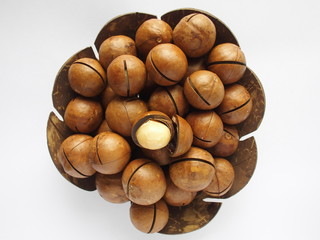 macadamia in utensil made from coconut shell on white background