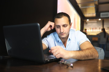 Armenian handsome man working behind laptop