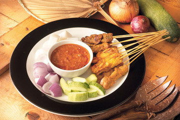 Asian food satay served with onion and cucumber
